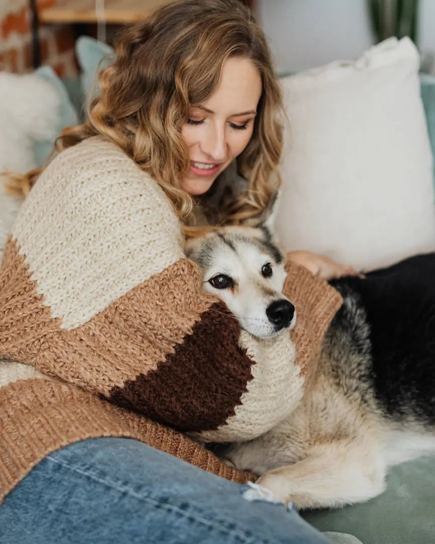 Woman cuddling her dog on the sofa